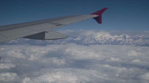 Wolken und Himalaya unter der Tragfläche eines Flugzeugs — Stockvideo