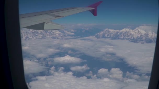 Wolken und Himalaya unter der Tragfläche eines Flugzeugs — Stockvideo