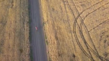 Bir bisikletçi yolun tarım alanları arasında sürmek