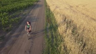 Bir bisikletçi yolun tarım alanları arasında sürmek