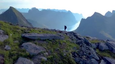 Kız bir sırt çantası ile bir dağ sırtı üzerinde yükselir