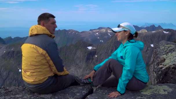 Мужчина и женщина сидят на вершине камня — стоковое видео