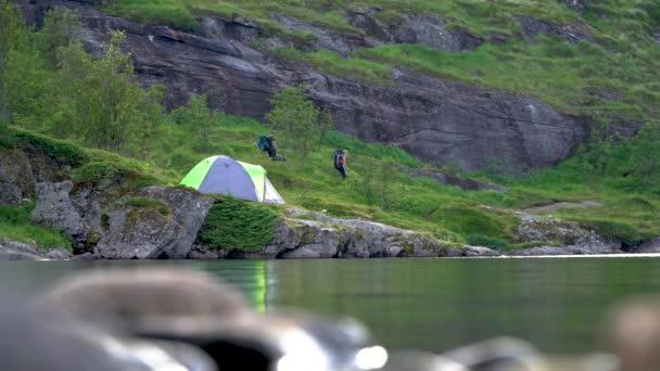 Turister och tältplatser nära sjön — Stockvideo