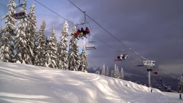 Remonte lleva esquiadores y snowboarders en la montaña . — Vídeos de Stock