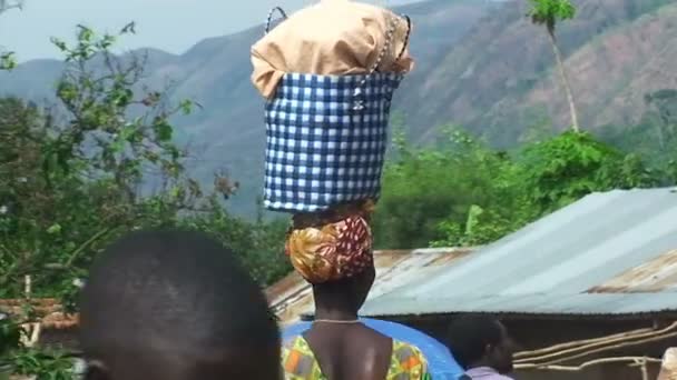 Woman walking with machete and basket on head — Stock Video