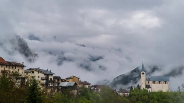 Nuages se déplacent sur la vallée de montagne et village alpin — Video