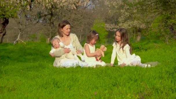 Мама з трьома дочкам відпочинок в парку — стокове відео