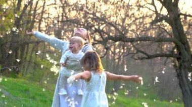 Mutlu genç anne parkta kızları ile oynuyor