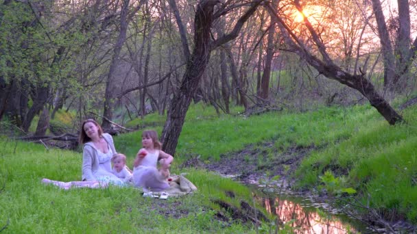 Moeder en dochters in het bos in de buurt van de beek — Stockvideo