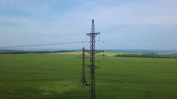 Högspännings effekt pylon på det gröna fältet — Stockvideo