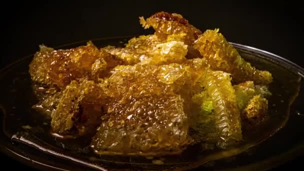 Os favos de mel giram em um prato de vidro — Vídeo de Stock
