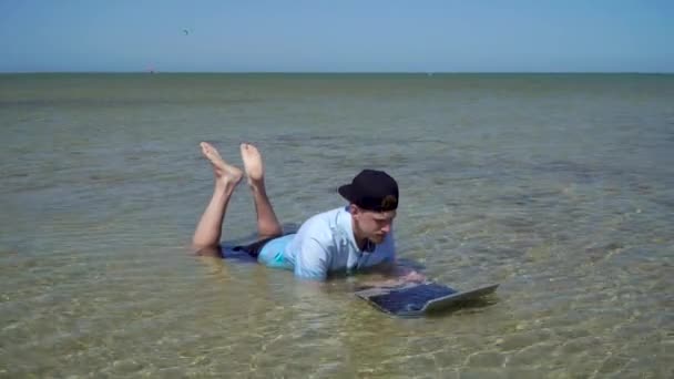 Een man werkt op vakantie. De man in de zee met een laptop. — Stockvideo