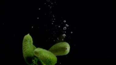 Salatalık yavaş çekim yakın çekim suya düşüyor.