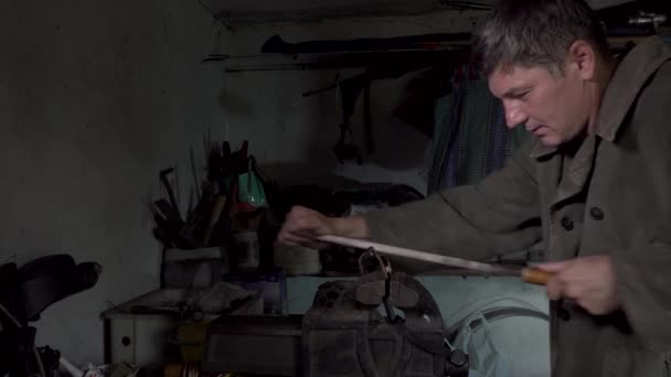 Un hombre trabaja en un viejo taller en casa — Vídeo de stock