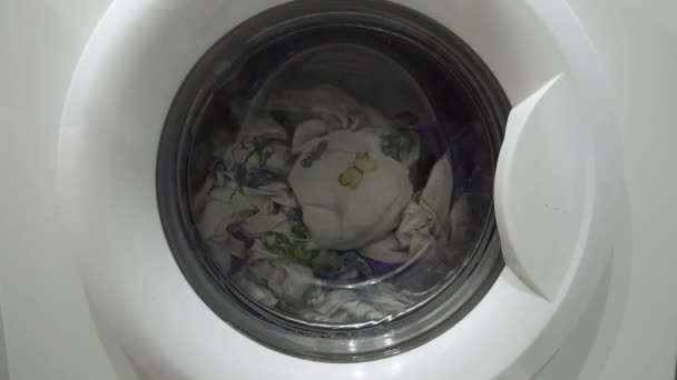 Beyaz çamaşır makinesi kirli renkli giysileri yıkar. — Stok video