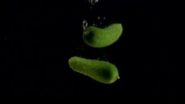 Salatalık yavaş çekim yakın çekim suya düşüyor.