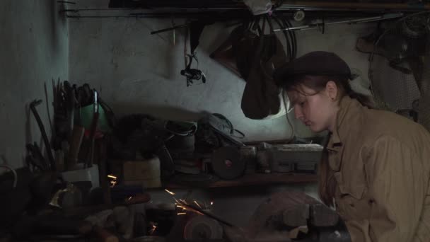 En tjej jobbar i en gammal verkstad. — Stockvideo