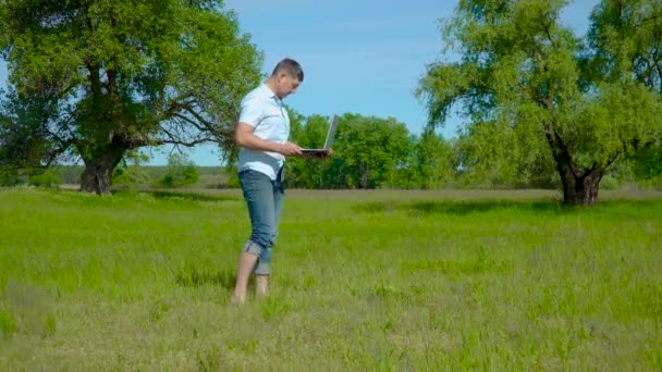 Biznesmen pracuje za laptopem na trawniku — Wideo stockowe