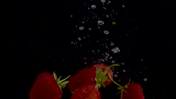 Aardbei slow motion close-up vallen in het water — Stockvideo