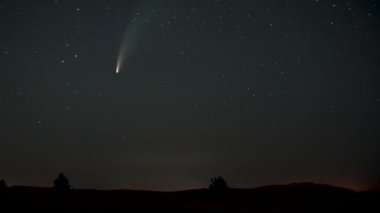 Kuyruklu yıldız yıldızların arasında gece gökyüzünde hareket eder.
