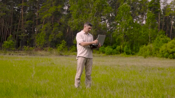 Homme d'affaires travaille derrière un ordinateur portable sur la pelouse — Video