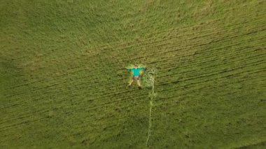 Bir adam yeşil çimlerin üzerinde yatıyor.