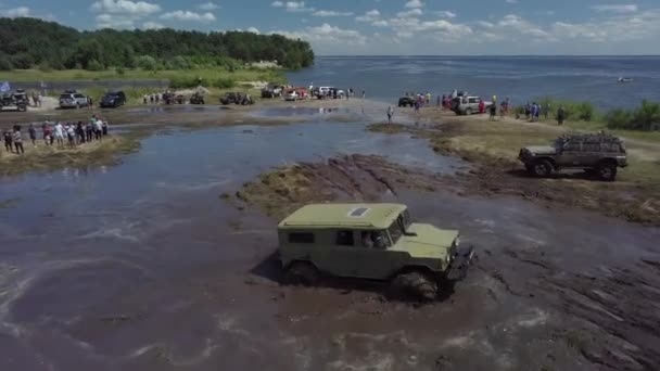 Festival of off-road lovers. SUVs drive the swamp. Cars skid in the mud. — Stock Video