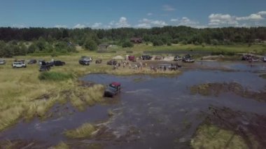 Off-road aşıkları festivali. Cipler bataklığı sürüyorlar. Arabalar çamurda kayar..