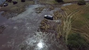 Off-road aşıkları festivali. Cipler bataklığı sürüyorlar. Arabalar çamurda kayar..