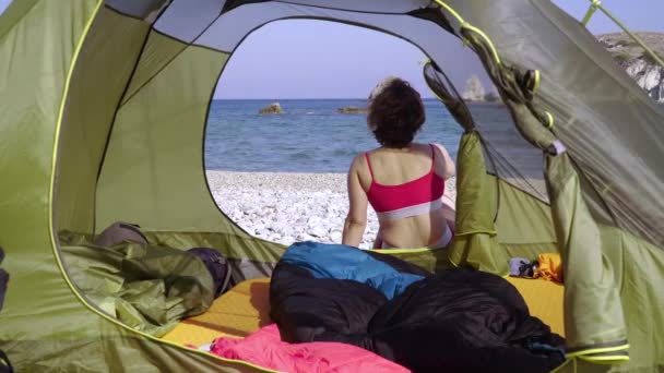 Mayo giymiş bir kadın kumlu bir sahilde kamp yapıyor. — Stok video