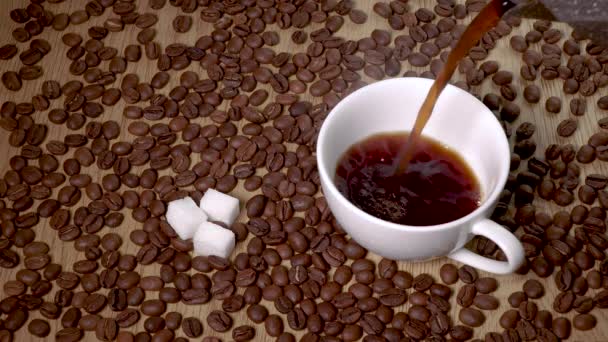 Heißer Kaffee wird aus einer Kaffeekanne in eine Tasse gegossen — Stockvideo