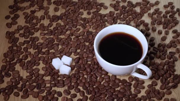 Cukordarabok esnek egy csésze fekete kávéba. — Stock videók