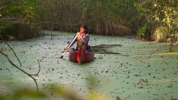 坐在独木舟上的牛仔在河边漂流 — 图库视频影像