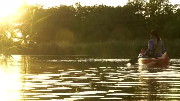 Cowboy in een kano drijft op de rivier — Stockvideo