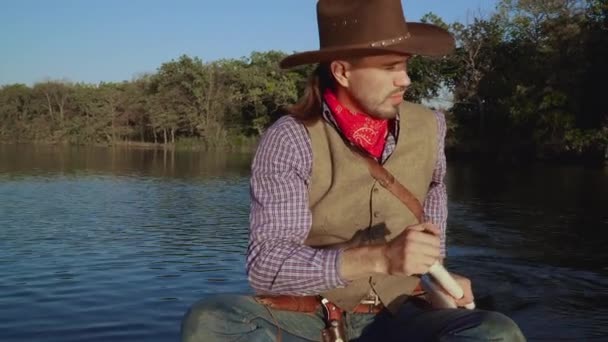 Cowboy in een kano drijft op de rivier — Stockvideo