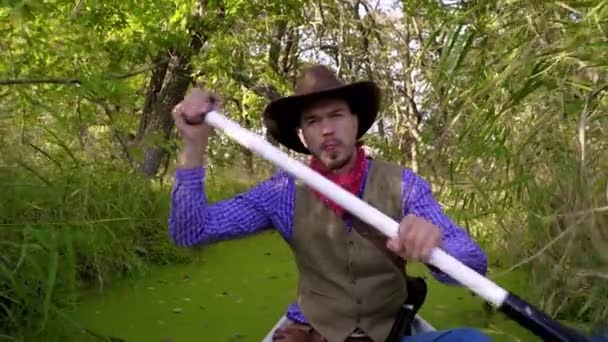 Cowboy em uma canoa flutua no rio — Vídeo de Stock