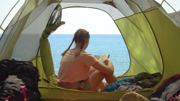 Дівчина читає книжку в наметі — стокове відео