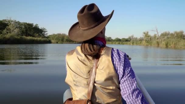 Cowboy in een kano drijft op de rivier — Stockvideo