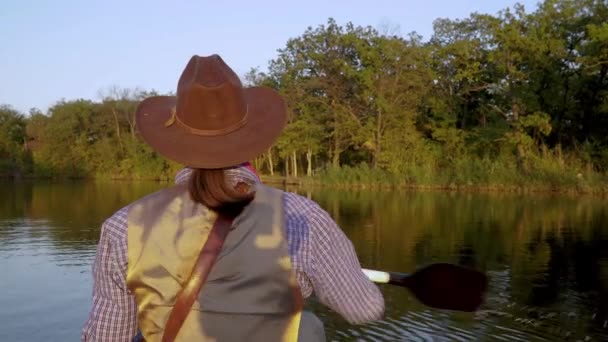 Vaquero en una canoa flota en el río — Vídeos de Stock