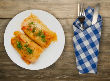 lahana bir tabak içinde alır. lahana bir ahşap arka plan üzerinde rulo. et lahana Üstten Görünüm.