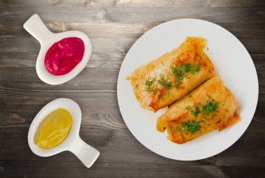 lahana bir tabak içinde alır. lahana bir ahşap arka plan üzerinde rulo. et lahana Üstten Görünüm.