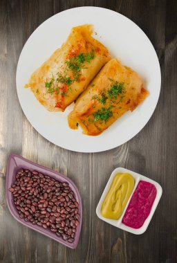 lahana bir tabak içinde alır. lahana bir ahşap arka plan üzerinde rulo. et lahana Üstten Görünüm.