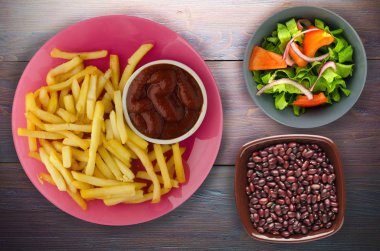 ahşap bir zemin üzerine ketçap ile kızarmış patates. patates kızartması bir plaka üzerinde