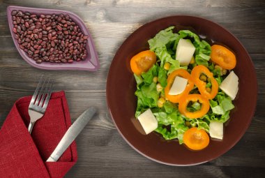  salata, peynir, salata, Mısır, biber ahşap arka plan üzerinde. Vejetaryen salata bir plaka üzerinde. Vejetaryen salata Üstten Görünüm