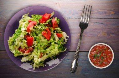 Vejetaryen Gıda. ahşap arka plan üzerinde bir tabakta lahana domates salatası. sağlıklı gıda