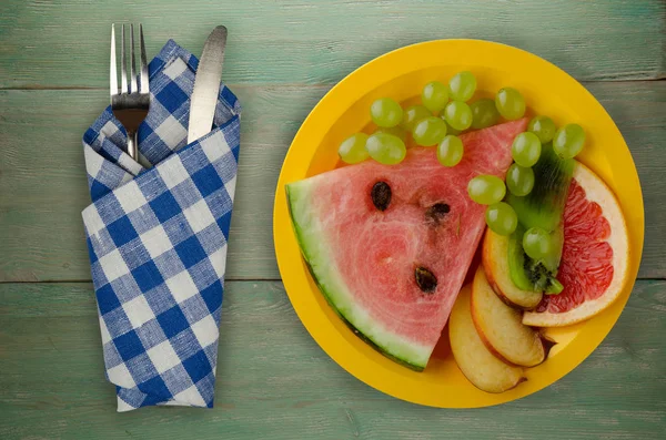 meyve bir ahşap arka plan üzerine dilimlenmiş. meyve bir tabağa dilimlenmiş