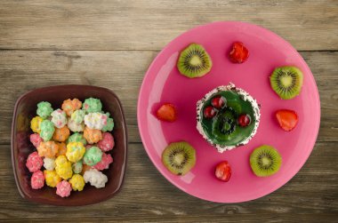 tatlı kek kivi ve çilek ahşap arka plan üzerinde. Festival tatlı bir plaka Üstten Görünüm