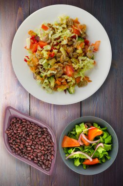 salata tavuk mideleri sebzeler (havuç, soğan, biber, lahana, domates, brokoli) ile. ahşap arka plan üzerinde bir tabakta Tavuk salatası