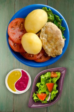  göğsü bir tabak patates ile. göğsü ahşap arka plan üzerinde patates ile