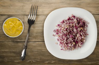 ahşap arka plan üzerinde kırmızı soğan. bir plaka üzerinde doğranmış kırmızı soğan